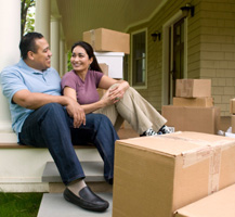 Man and woman sitting on porch with moving boxes