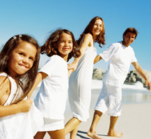 Family holding hands walking on the beach