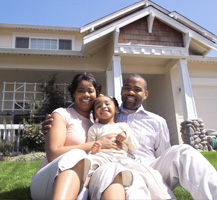 Family sitting in front of house