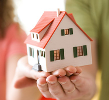 Hands holding small toy house