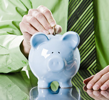 Man putting coins in piggy bank